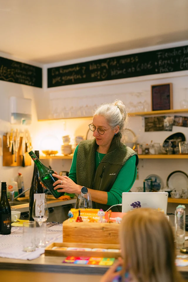 Die Korkenzieherin präsentiert im Weinladen eine Flasche Wein